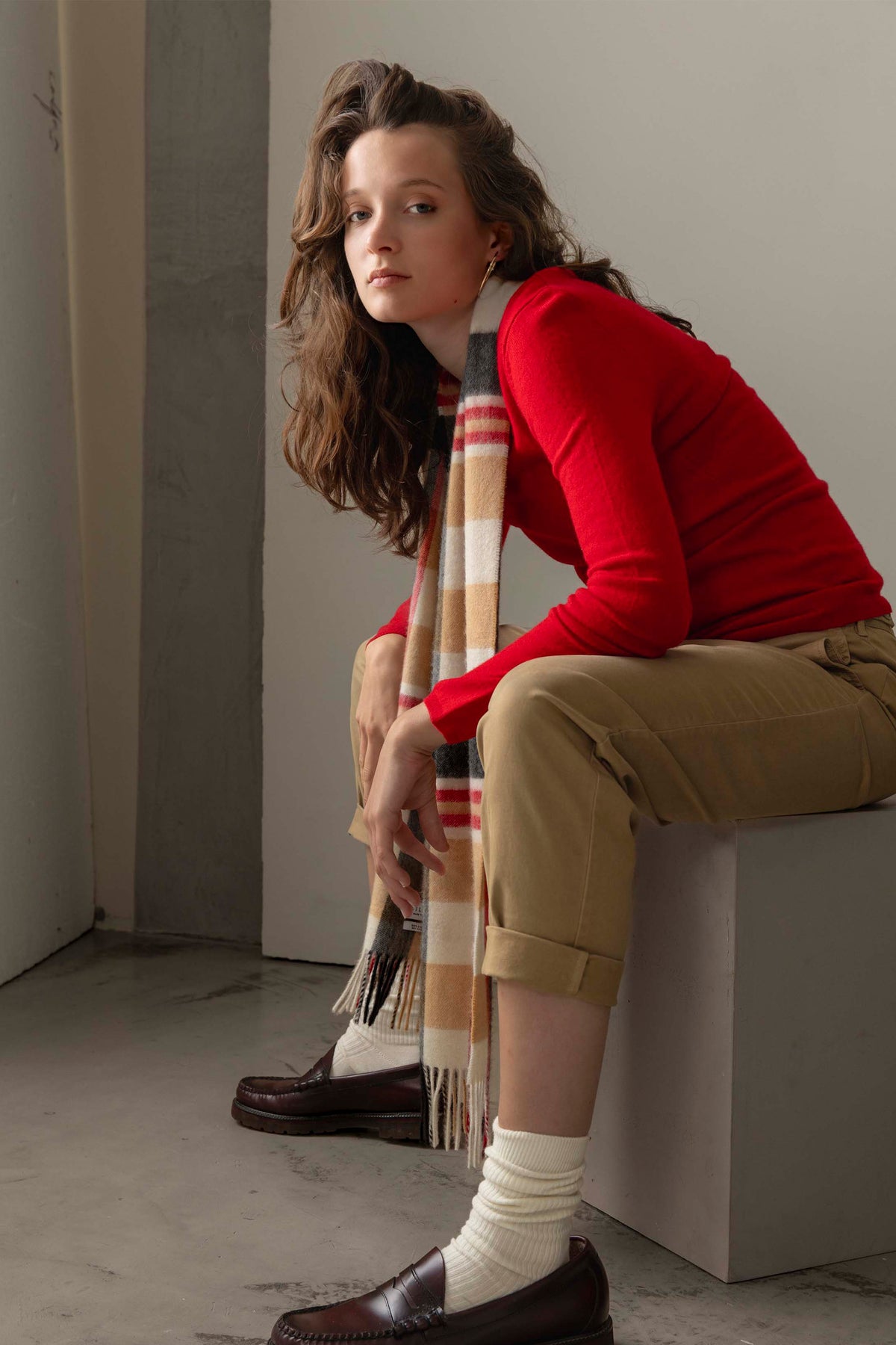 Women's Cashmere V Neck Jumper in red, styled on model with striped scarf, khaki trousers, and brown loafers