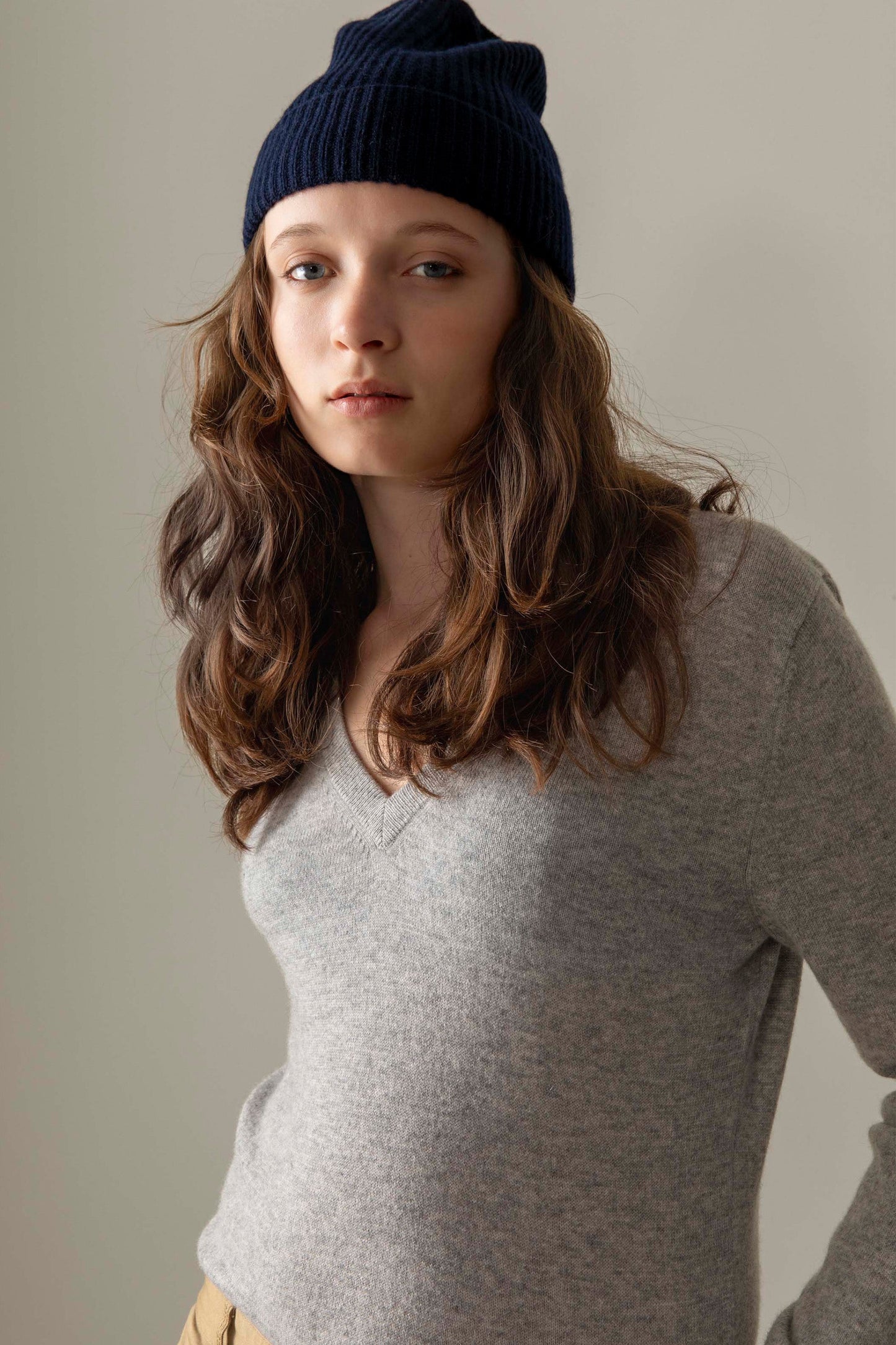Women's Cashmere V Neck Jumper in light grey, soft lightweight knit with ribbed V-neckline, styled with navy beanie