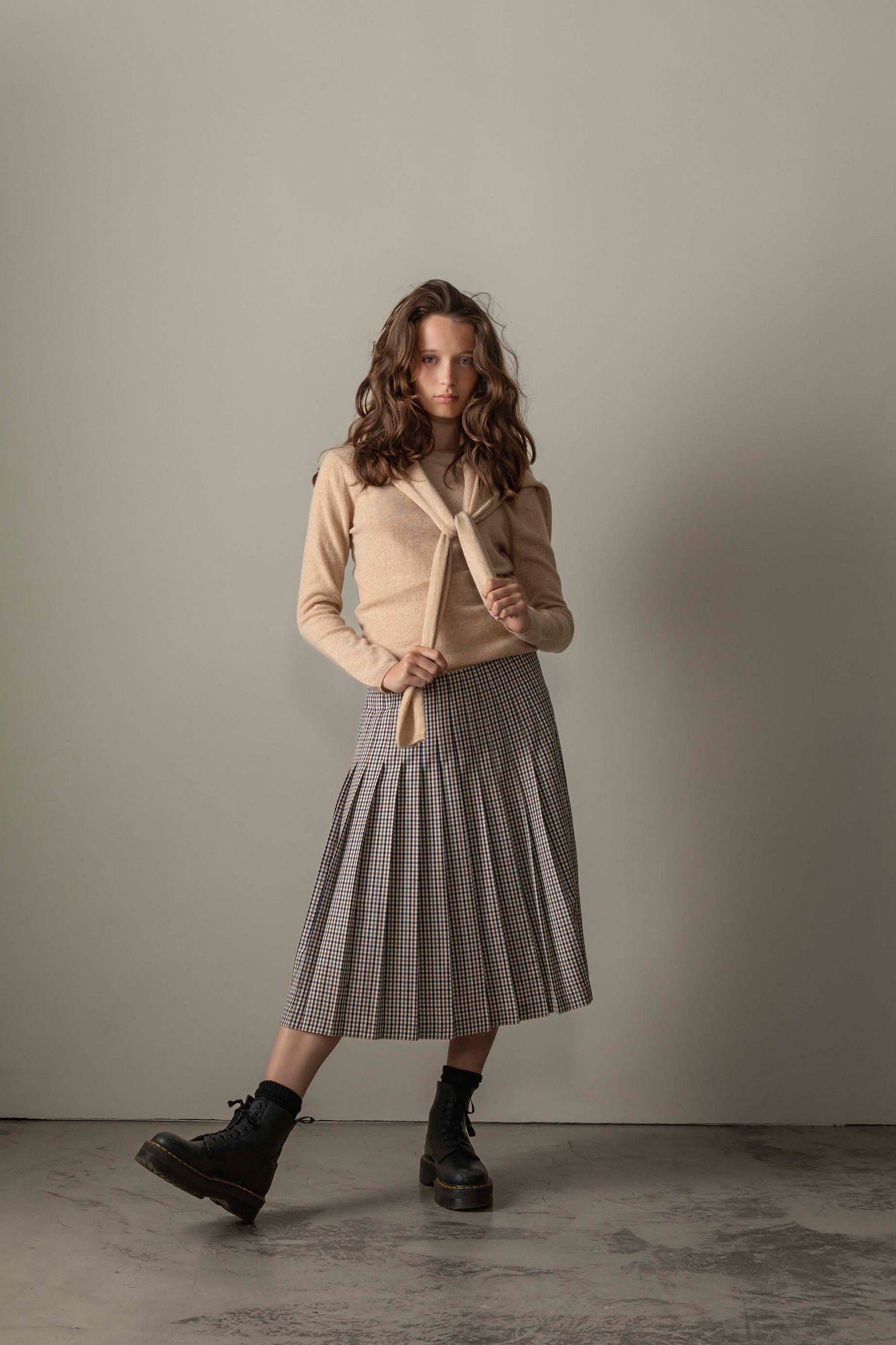 Women's Cashmere Crew Neck Jumper in Vicuna styled with a matching sweater tied over shoulders and gingham pleated skirt