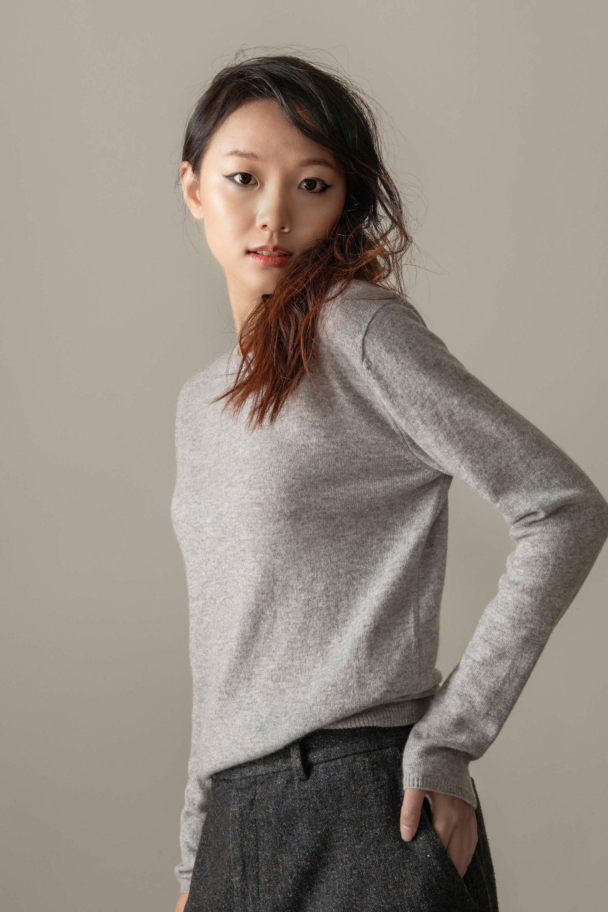 Model wearing Women's Cashmere Crew Neck Jumper in Light Grey, three-quarter back view showing slim fit and ribbed cuffs