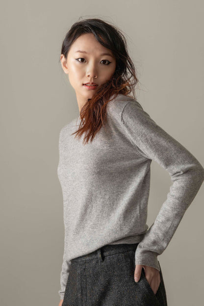 Model wearing Women's Cashmere Crew Neck Jumper in Light Grey, three-quarter back view showing slim fit and ribbed cuffs