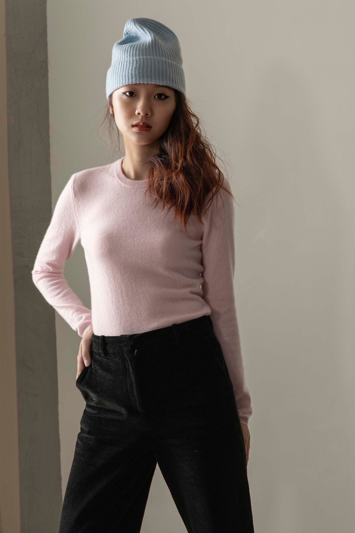 Model wearing Women's Cashmere Crew Neck Jumper in Pale Lilac, front view showing slim fit and soft texture, styled with black trousers