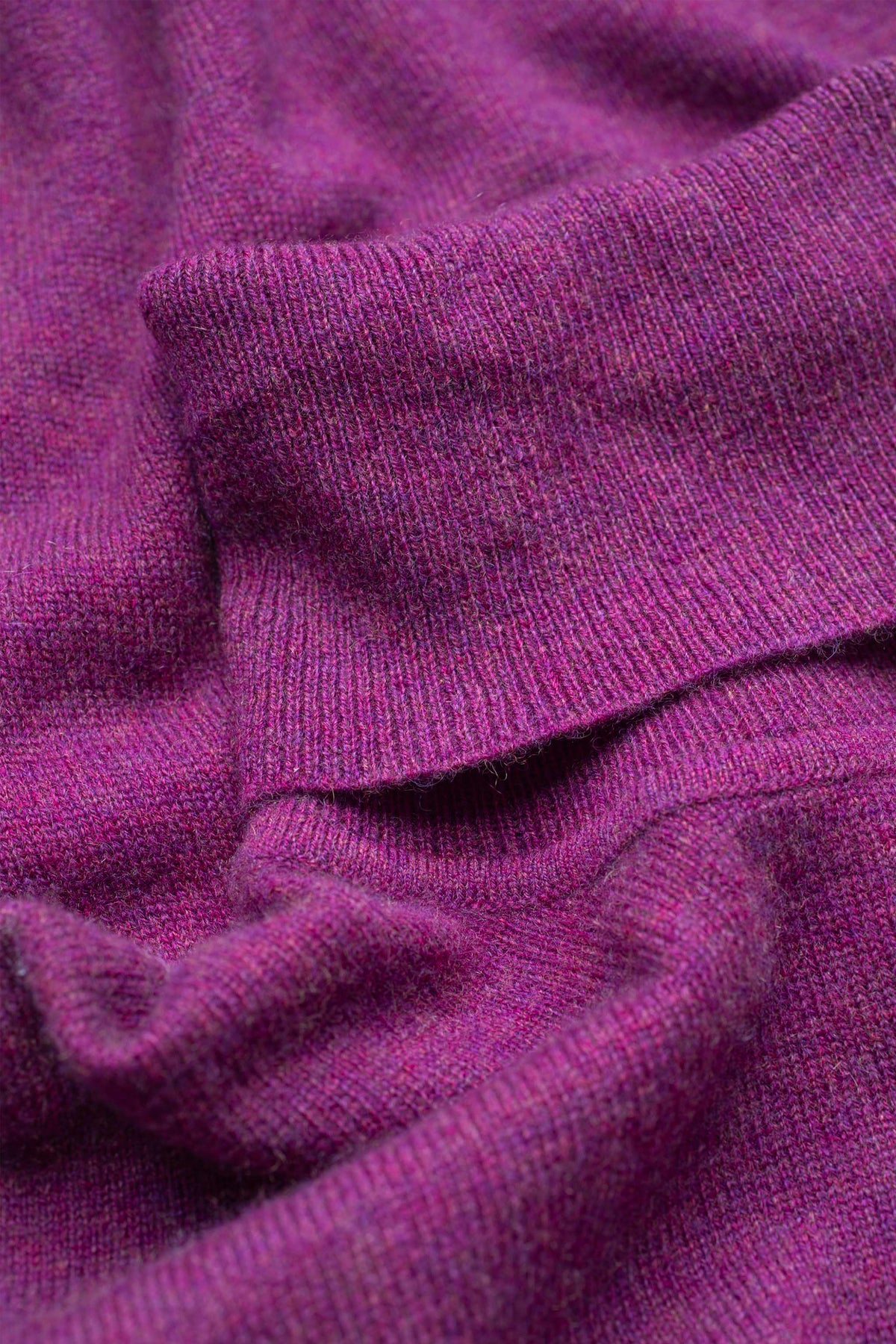 Close-up of the fine knit texture on the Women's Cashmere Polo Neck Jumper in Sloeberry, showing soft heathered purple fibres