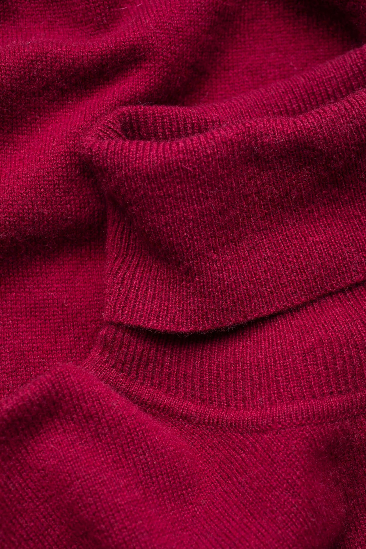 Close-up of the soft cashmere knit texture on the Women's Cashmere Polo Neck Jumper in rich bordeaux red