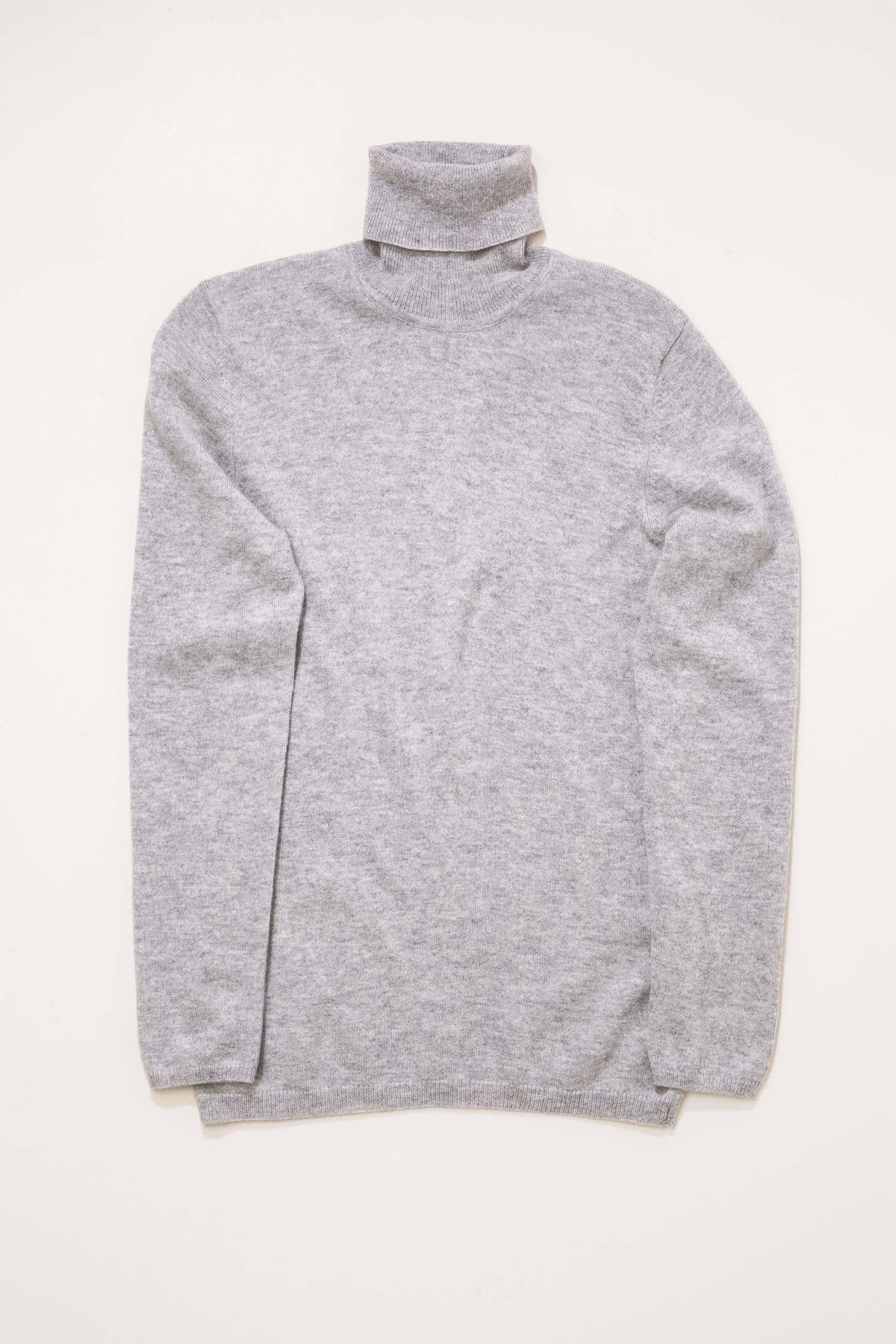 Women's Cashmere Polo Neck Jumper in light grey laid flat, showing full front view with folded turtleneck and relaxed fit