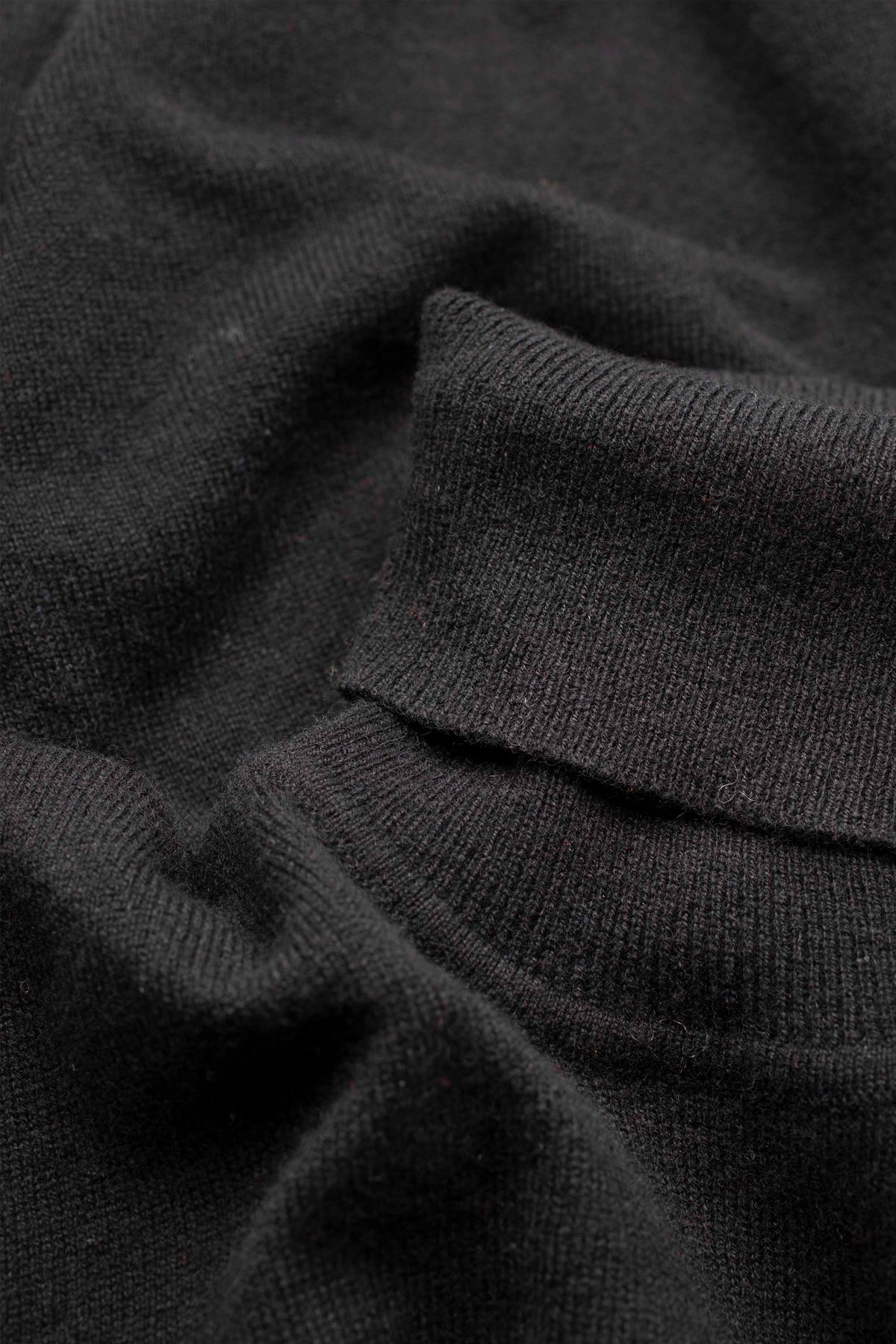 Close-up of the soft knit texture and ribbed polo neck detail on the Women's Cashmere Polo Neck Jumper in black