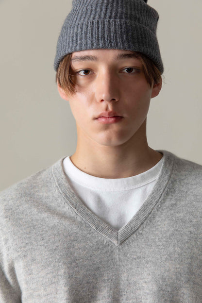 Close-up of Men's Cashmere V Neck Jumper in light grey, showing ribbed V-neckline detail layered over a white tee