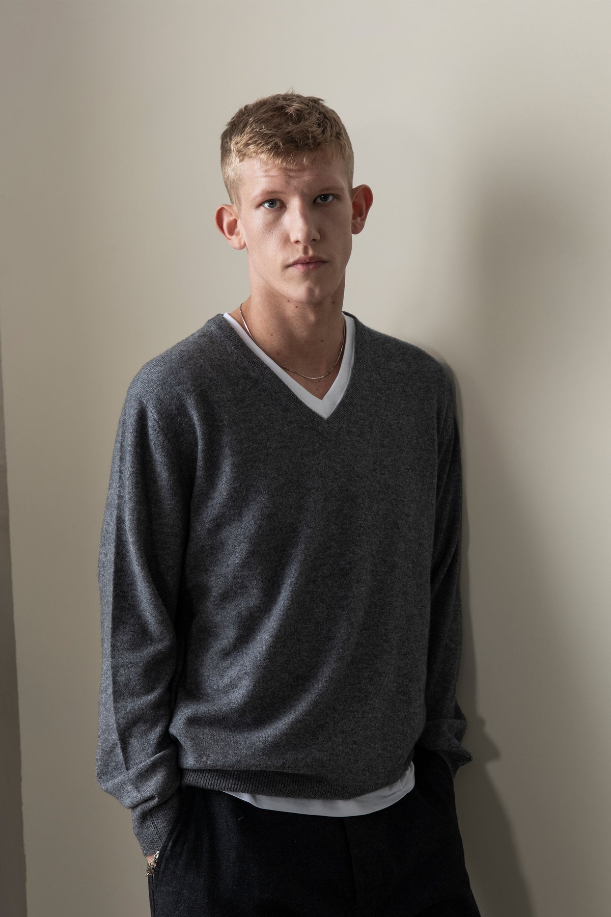 Men's Cashmere V Neck Jumper in Derby Grey styled over a white t-shirt, showing the relaxed fit and V-neck detail