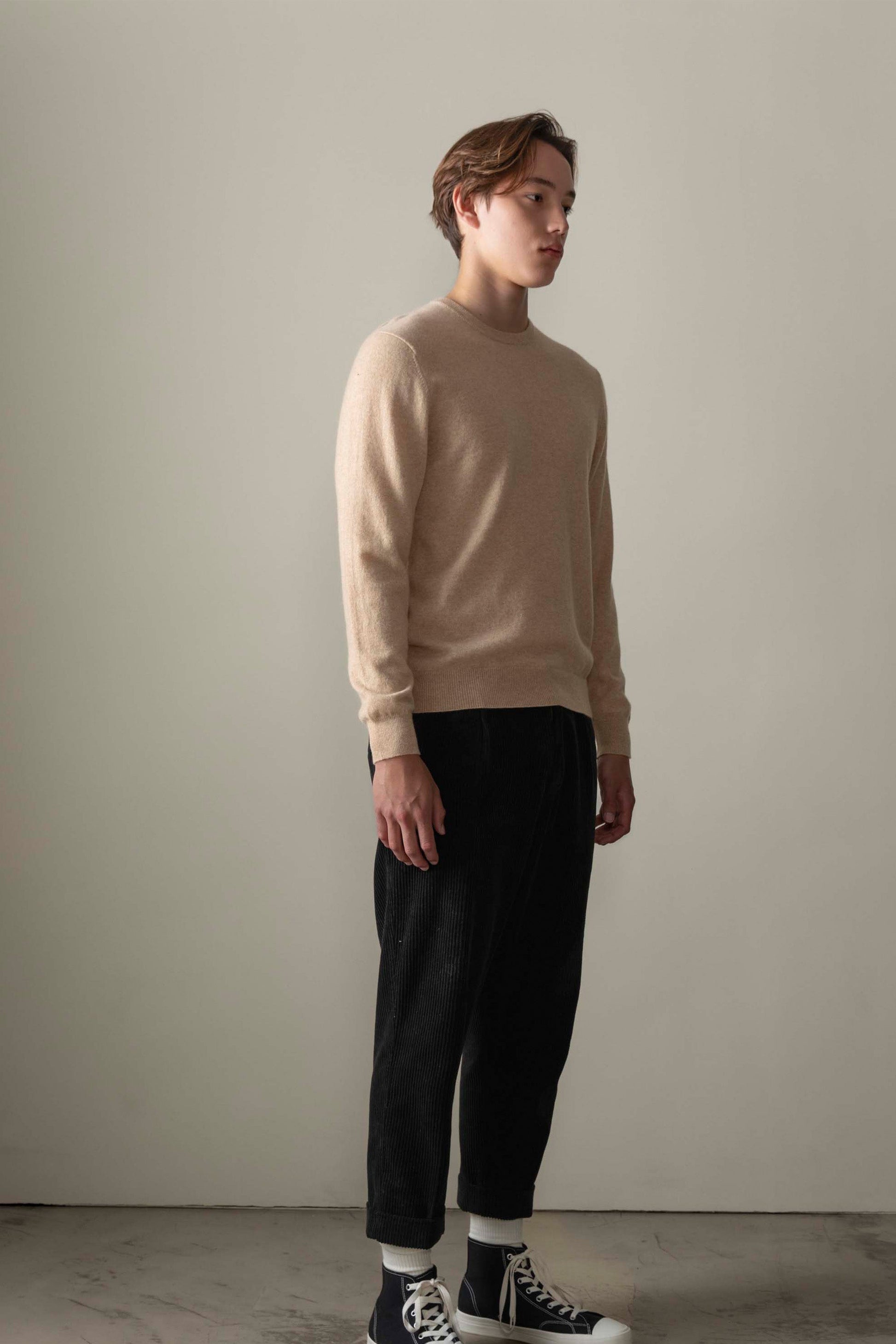 Men's Cashmere Crew Neck Jumper in Vicuna worn by model, three-quarter view showing relaxed fit and ribbed cuffs