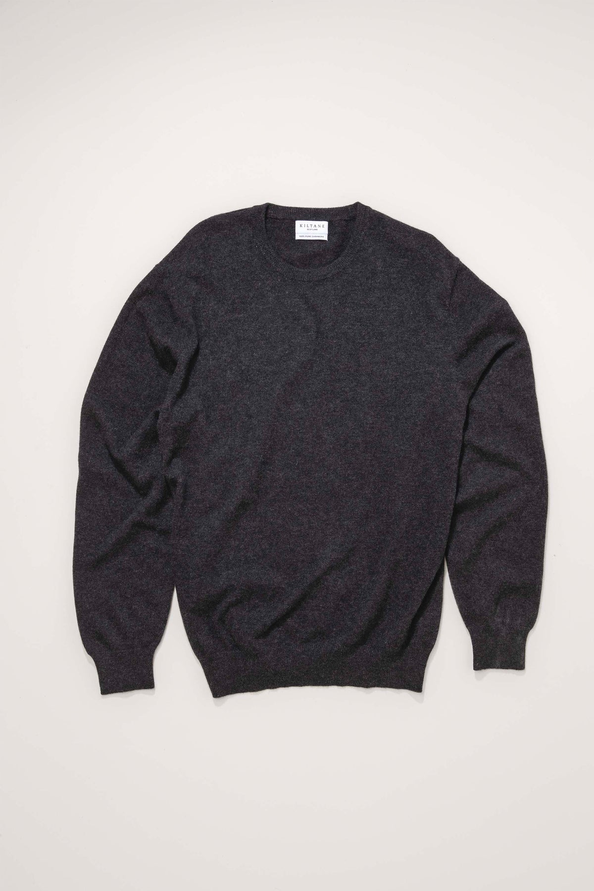 Kiltane Men's Cashmere Crew Neck Jumper in Charcoal laid flat, showing full front view with crew neckline and brand label