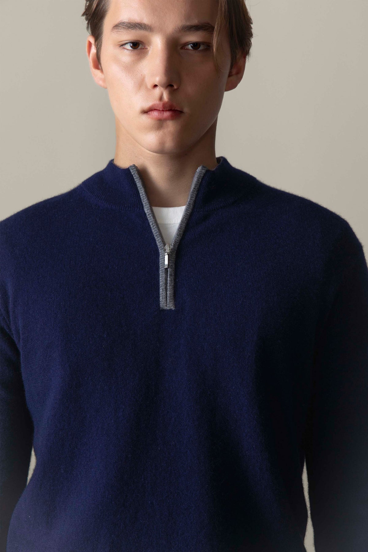 Close-up of the Men's Half Zip Jumper in navy cashmere showing grey contrast trim and silver zip pull at neckline