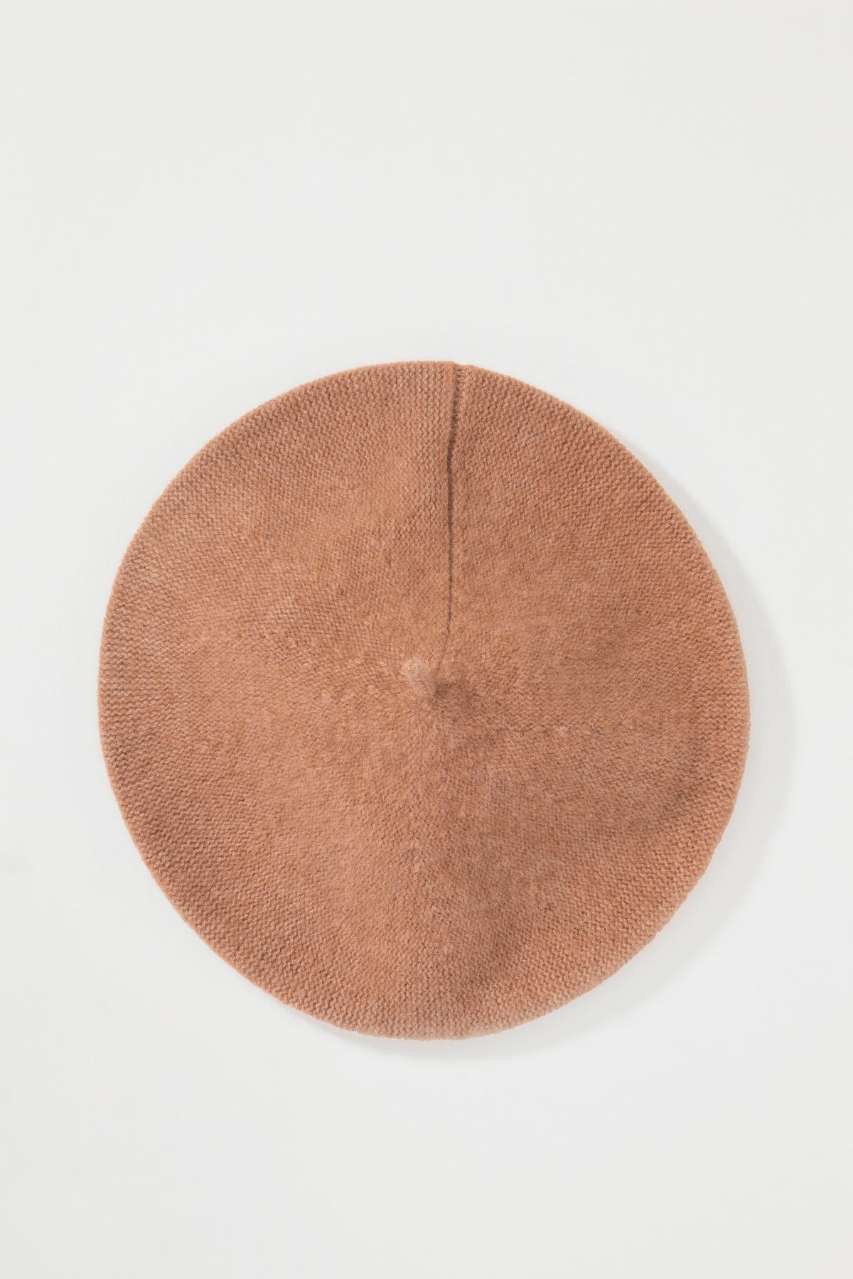 Top-down view of the Cashmere Knitted Beret in Camel showing the flat circular shape and centre seam detail