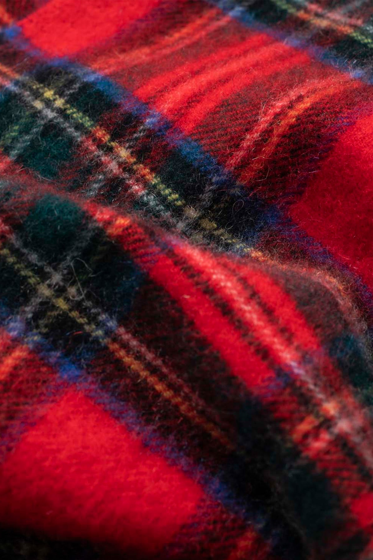 Close-up of the Royal Stewart tartan weave on the Made In Scotland Heritage Cashmere Scarf showing soft wool texture