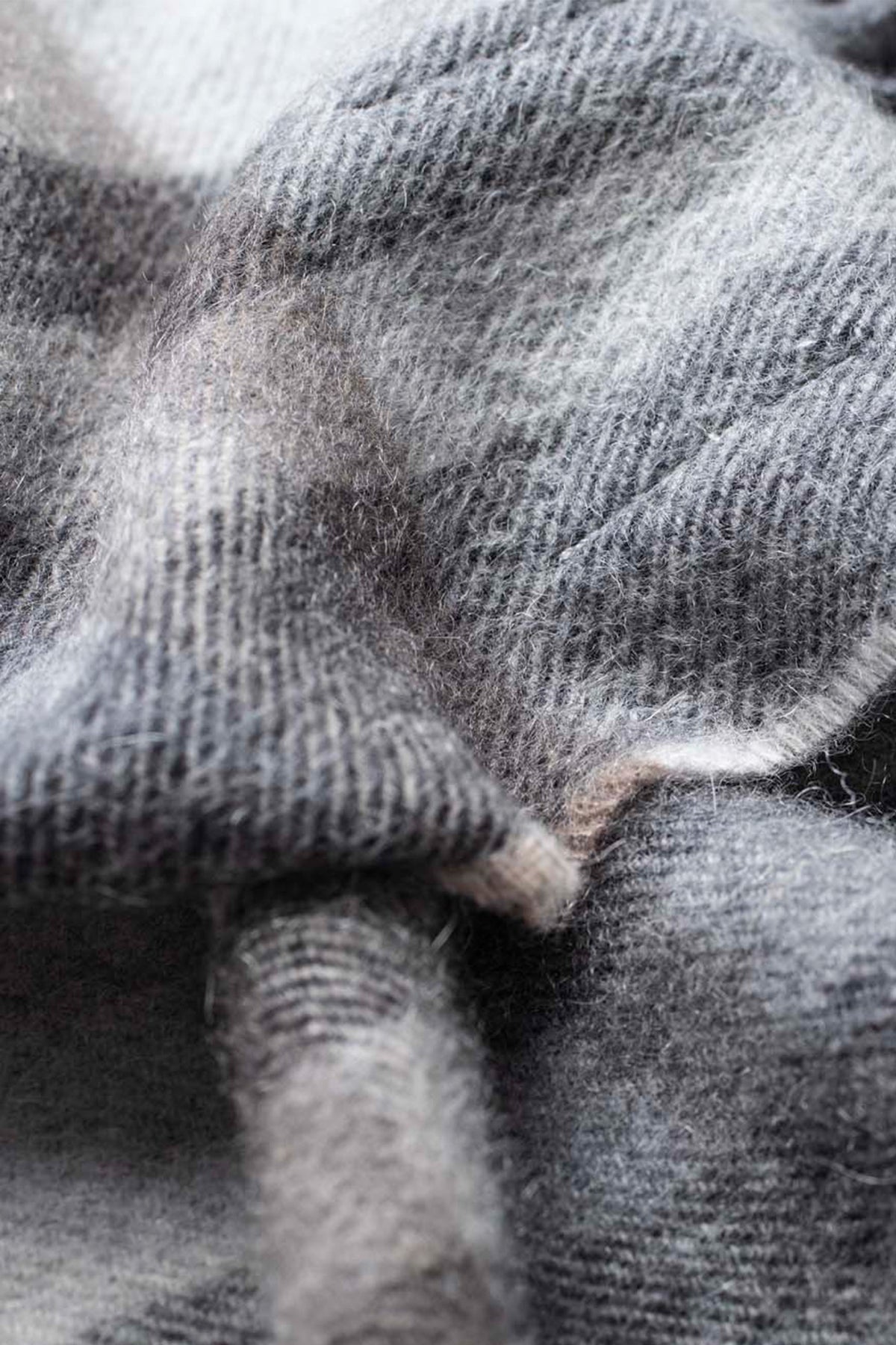 Close-up of the soft twill weave texture on the Made in Scotland Tartan 2 Cashmere Scarf in black and grey