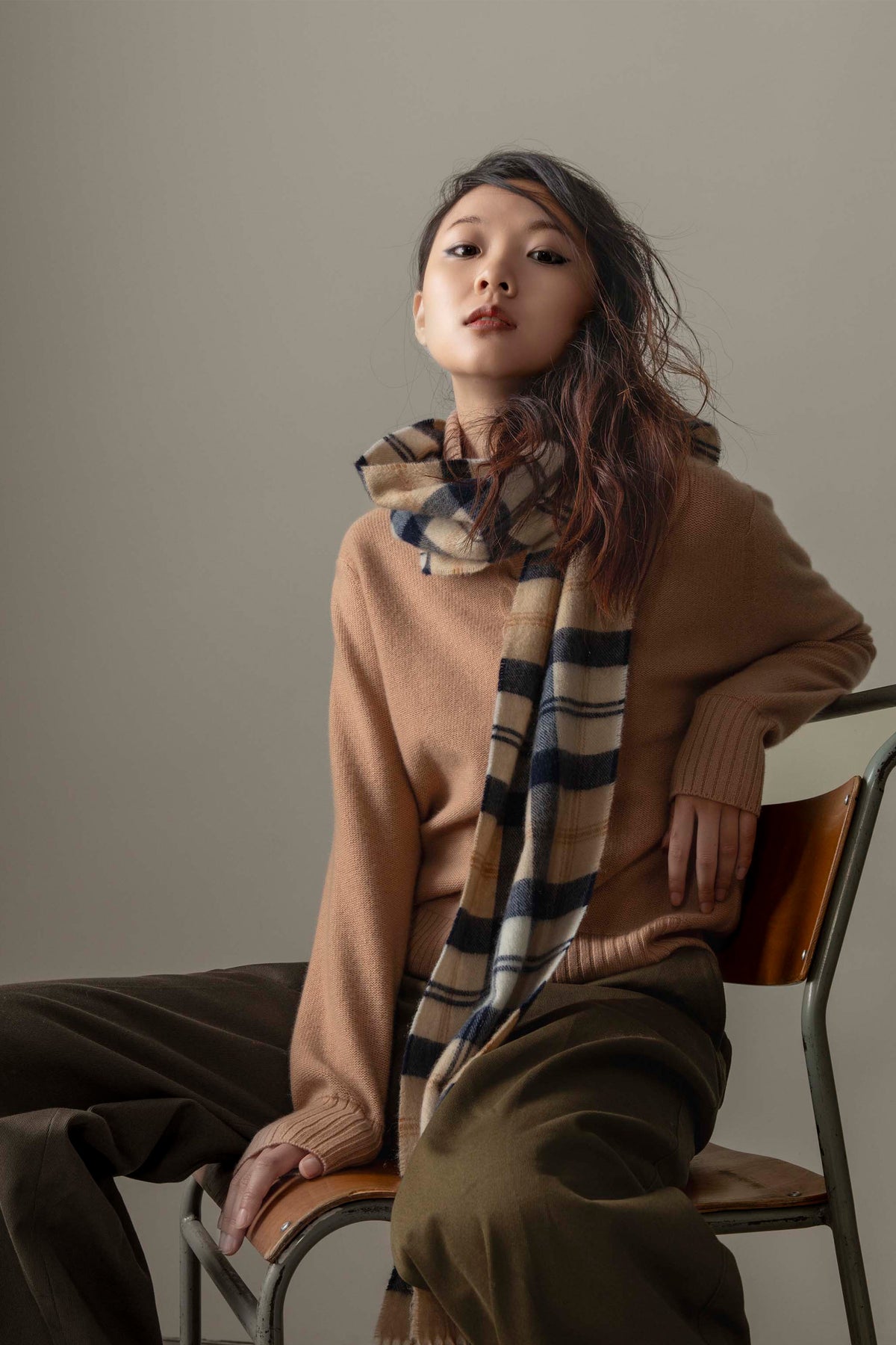 Made In Scotland Contemporary Cashmere Scarf in Navy Camel styled loosely around the neck over a camel sweater, showing plaid pattern detail