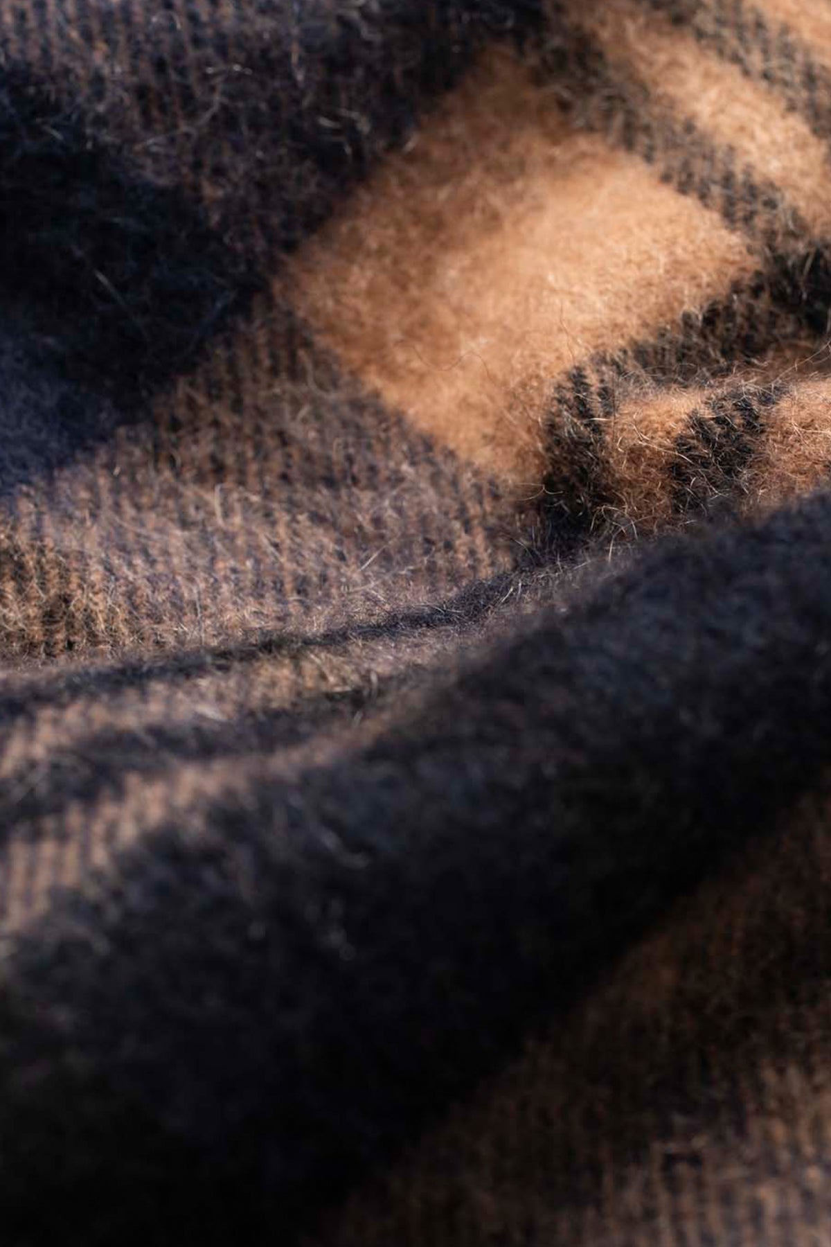 Close-up of the soft knit texture on the Made In Scotland Heritage Cashmere Scarf in Port Blackwatch navy and camel plaid