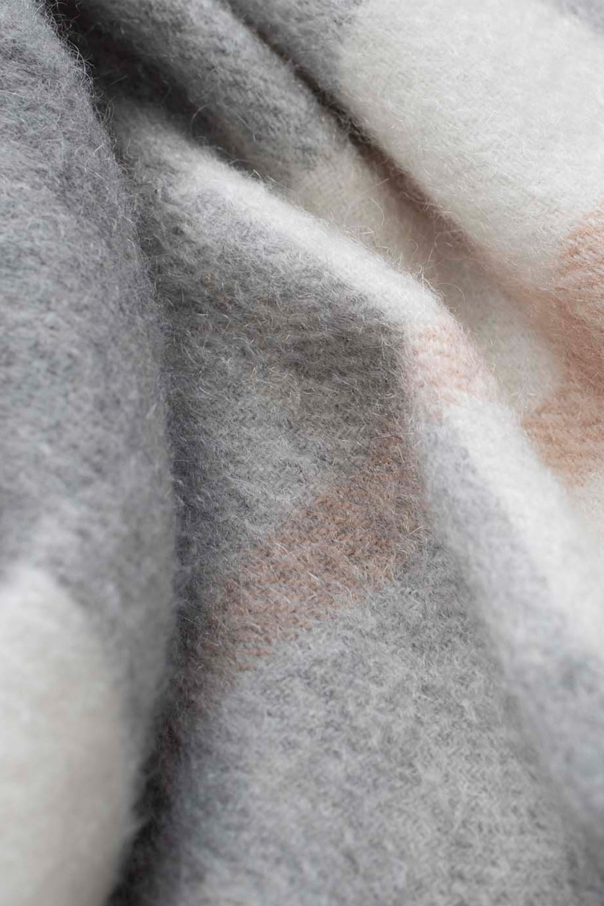 Close-up of the soft brushed cashmere texture on the Made In Scotland Contemporary Check Cashmere Stole in grey, cream, and blush