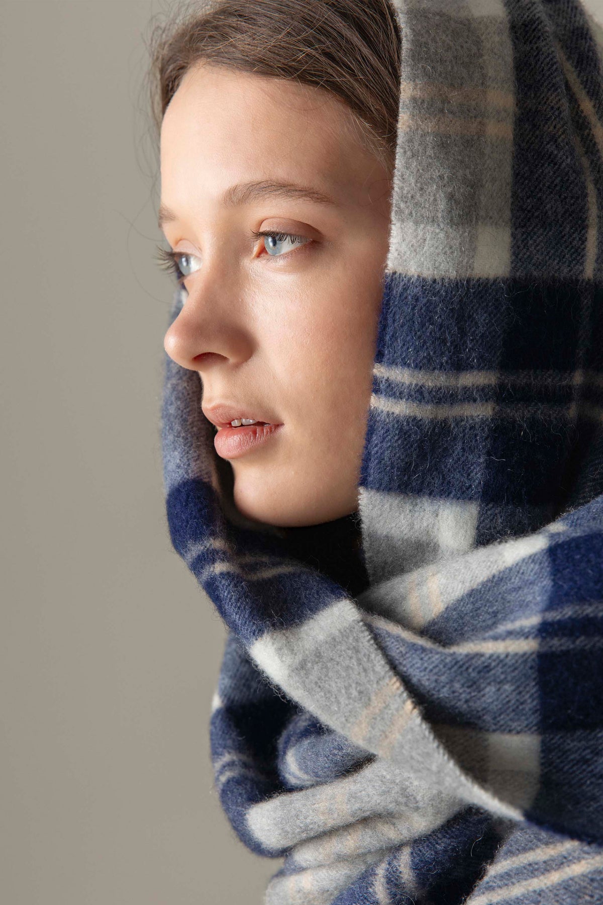 Heritage Cashmere Stole in Silver Bannockbane worn draped as a headscarf, showing soft wool texture in navy and grey plaid