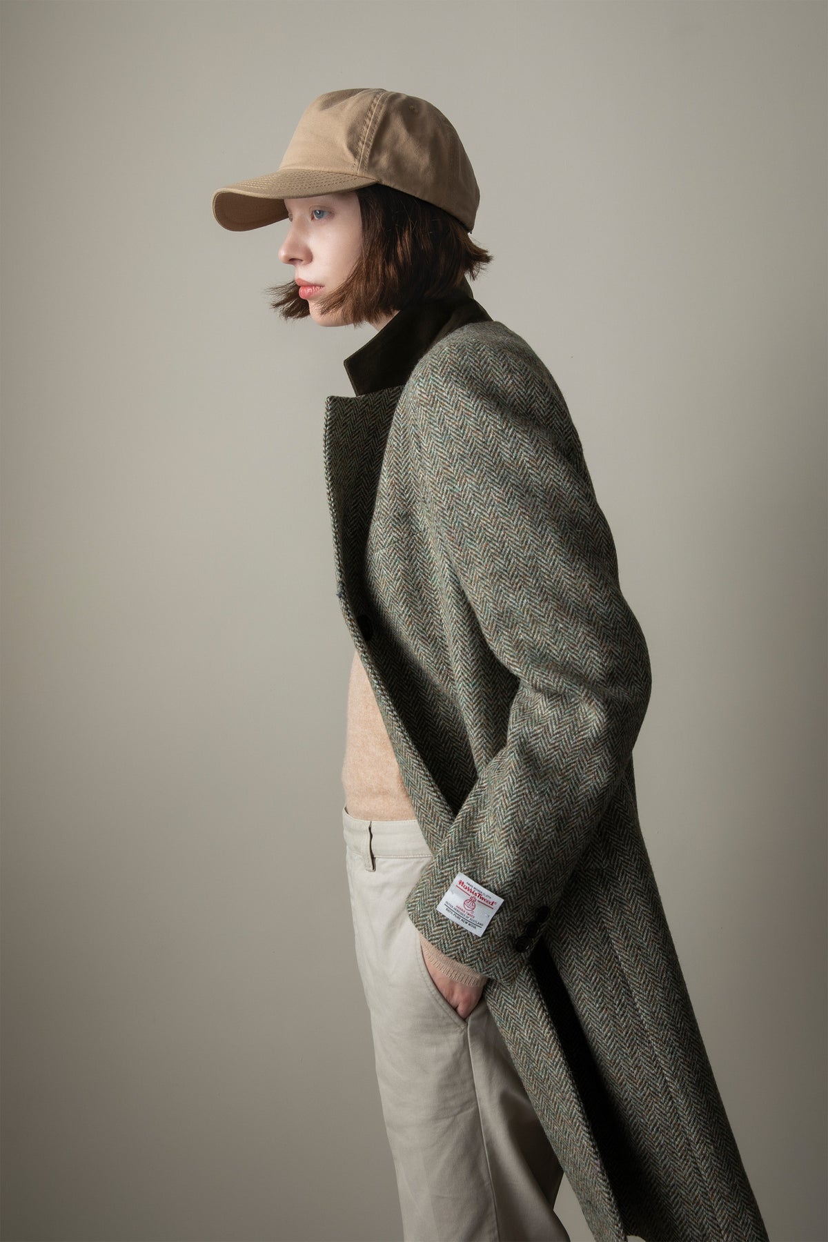 Women's Harris Tweed Tori Coat in Green Lovat Herringbone, side profile showing the classic tweed weave and relaxed fit