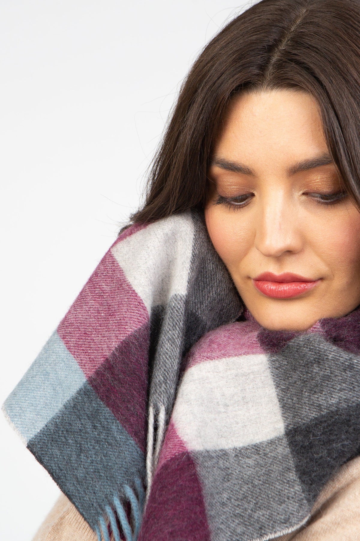 Model wearing Checkers Lambswool Scarf in Burgundy wrapped snugly around neck, showing soft wool texture and plaid pattern