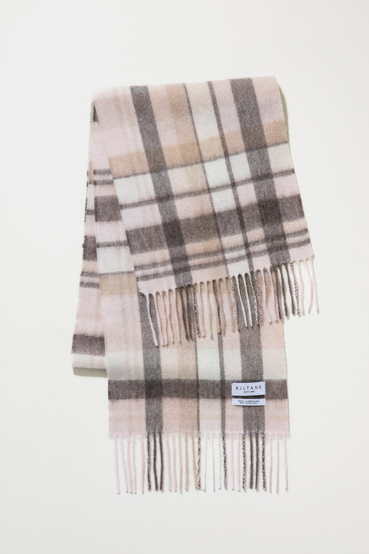 Kiltane Scotland label detail on Square Check Lambswool Scarf in Natural, showing pink, grey, and cream plaid with fringed ends
