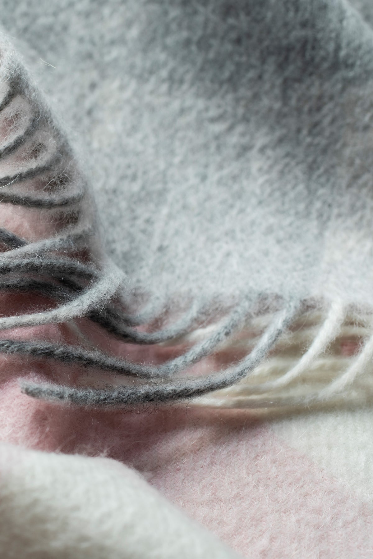 Close-up of 5 Square Check Lambswool Scarf in Cherub showing soft felted texture and twisted fringe in grey, pink, and cream