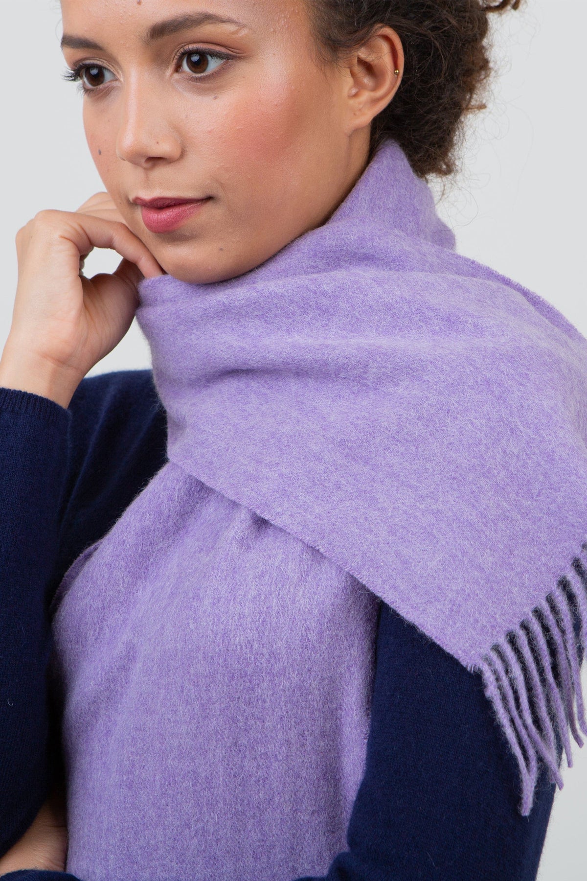 Solid Lambswool Scarf in Heather worn loosely wrapped around the neck, showing soft brushed texture and fringed ends