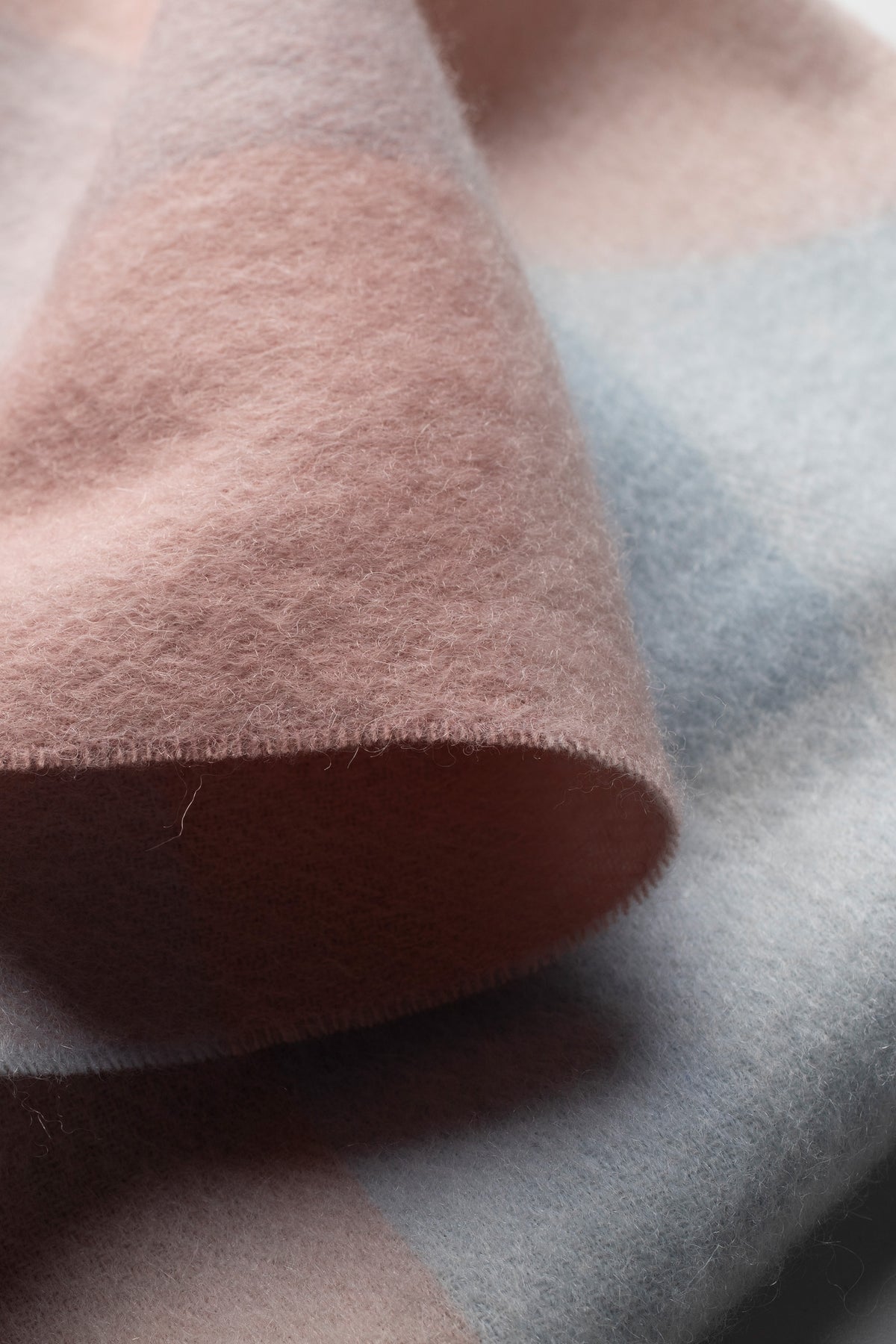 Close-up of 3 Square Check Lambswool Scarf in Seashell showing soft brushed texture and pink, blue, and brown colour blocks