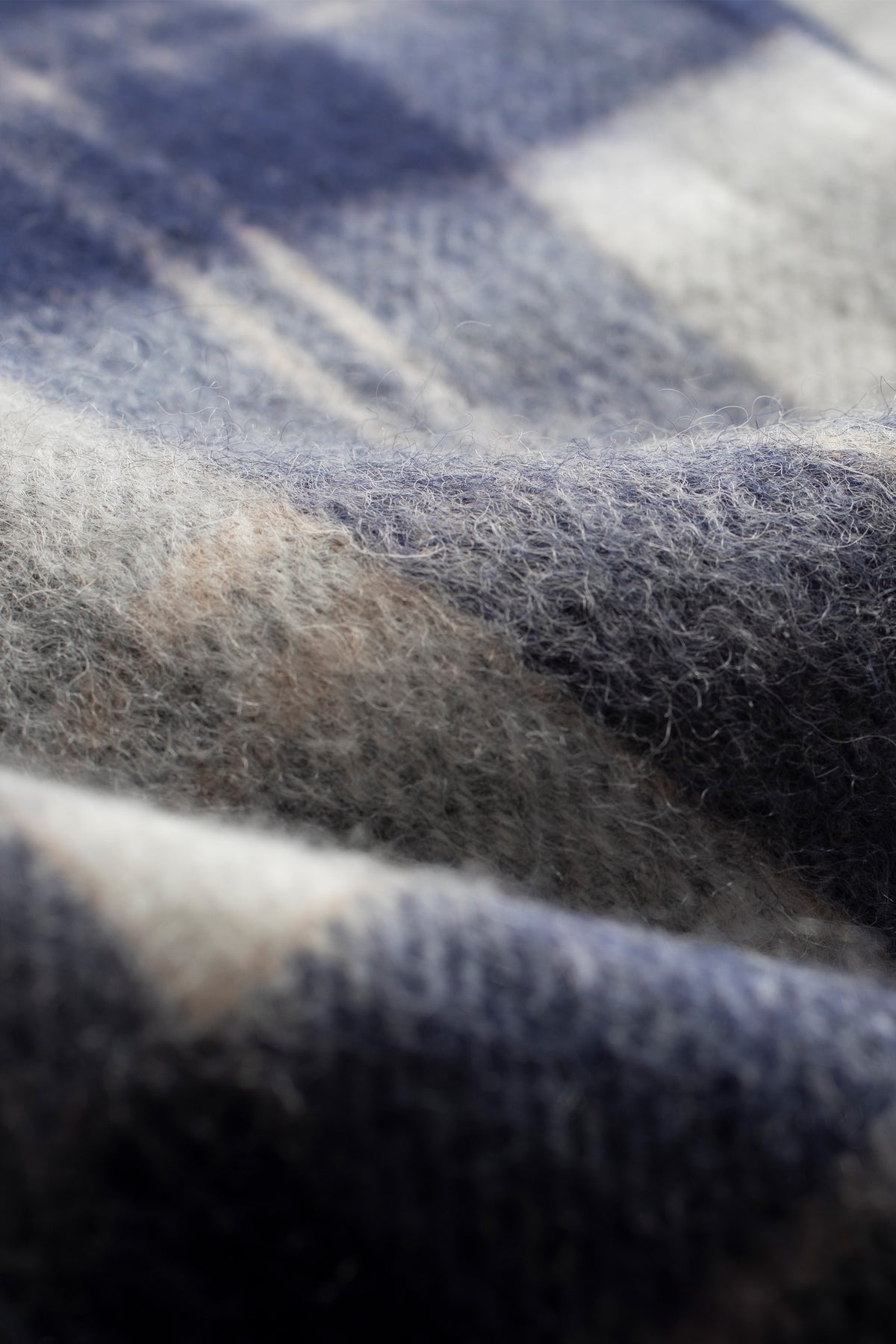 Close-up of Heritage Tartan Lambswool Scarf in Silver Bannockbane showing soft brushed wool texture and navy, cream, and tan plaid pattern