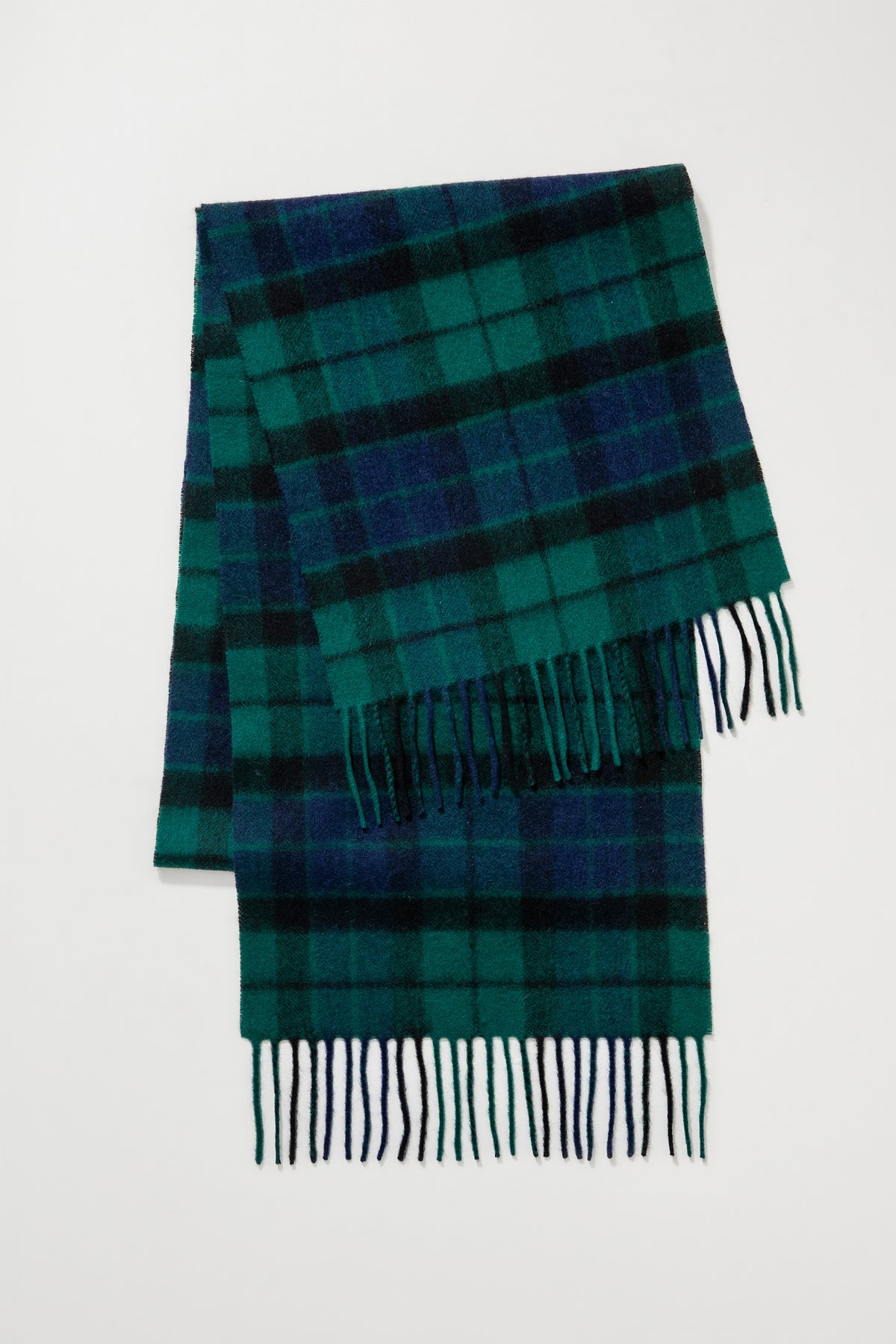 Heritage Tartan Lambswool Scarf in Blackwatch folded flat showing full tartan pattern in green, navy, and black with fringed ends
