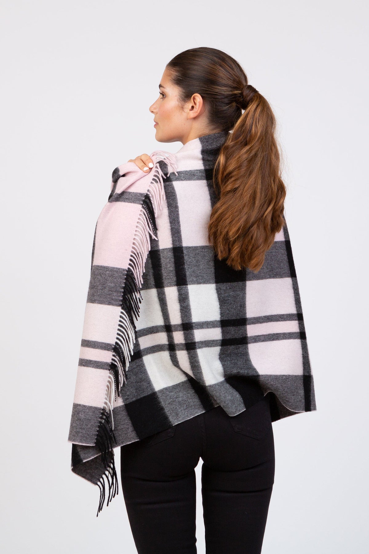 Back view of Contemporary Exploded Thompson Lambswool Stole in Baby Pink, showing plaid pattern and fringed edges draped over shoulders