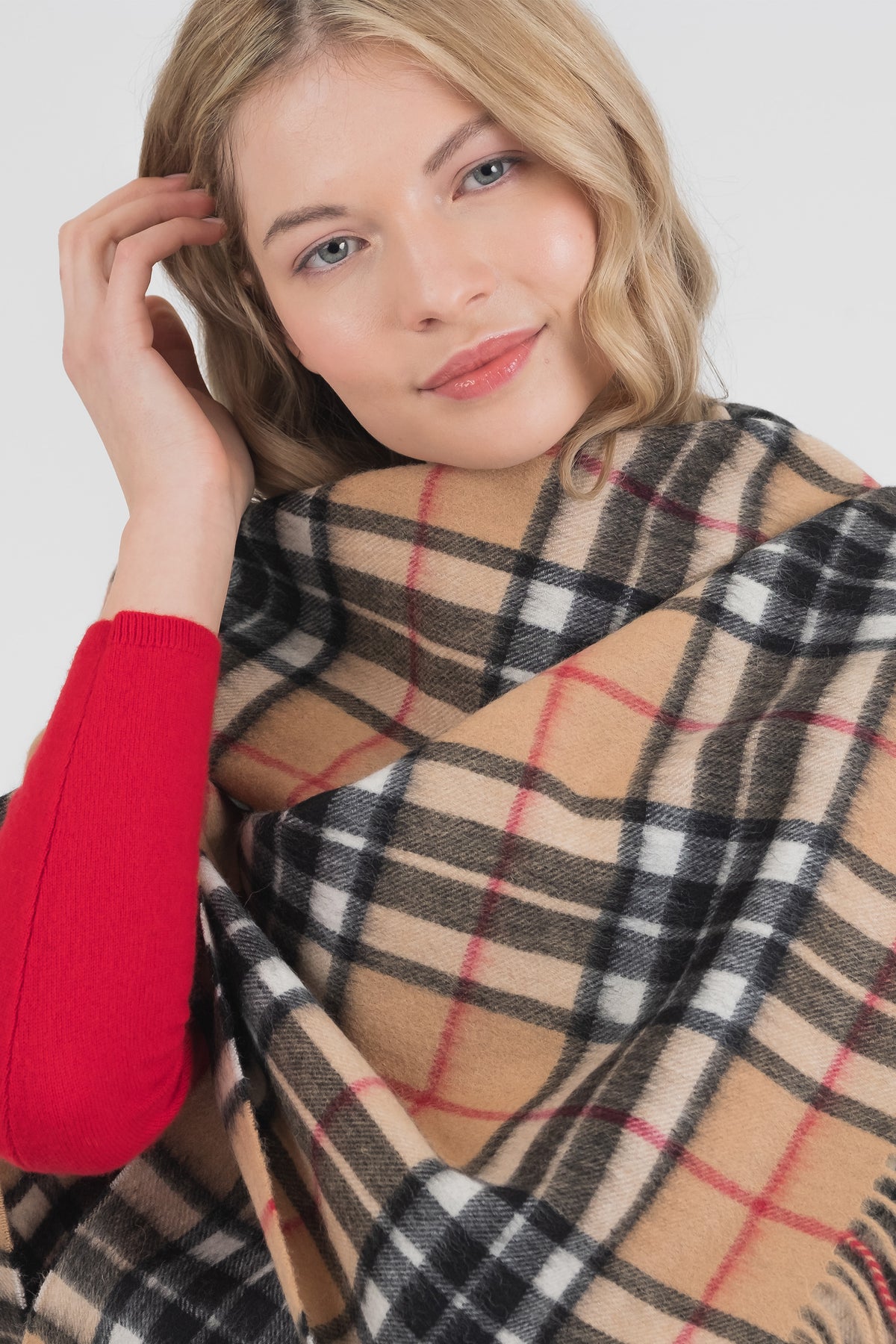 Model wearing the Scotty Thompson Lambswool Stole in Camel wrapped snugly around shoulders, showing the tartan plaid pattern detail