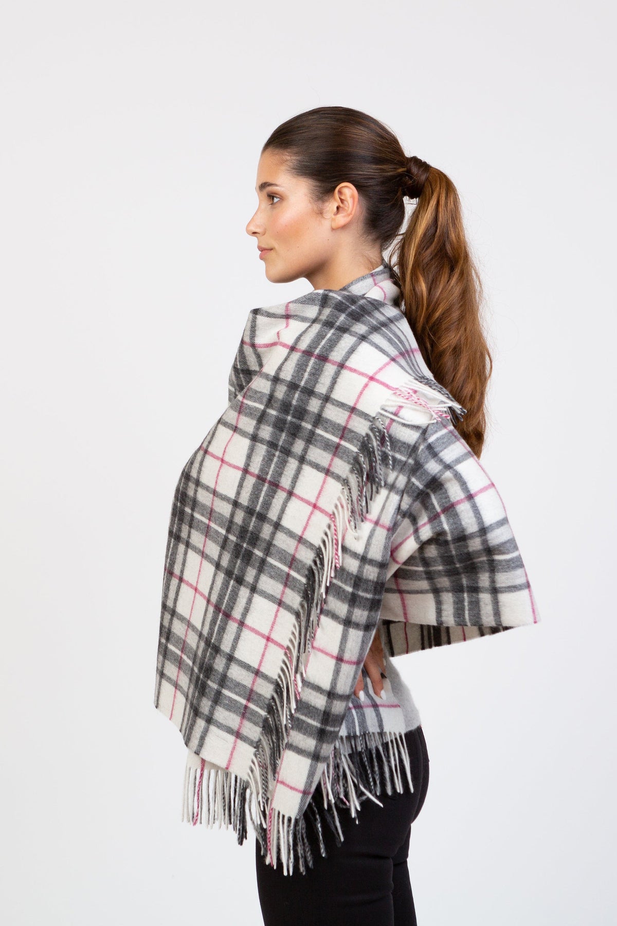 Side profile view of model wearing Scotty Thompson Lambswool Stole in White, showing plaid pattern with grey and pink lines and fringed edges