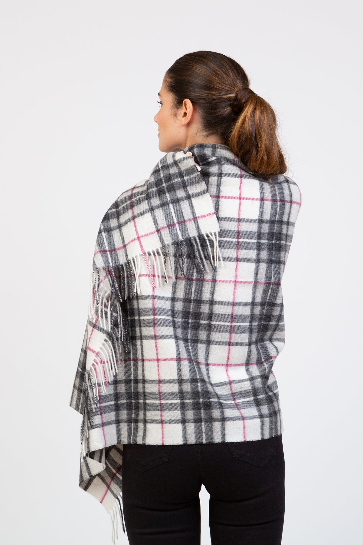 Back view of model wearing Scotty Thompson Lambswool Stole in White, showing full plaid pattern with grey and pink lines and fringed edges