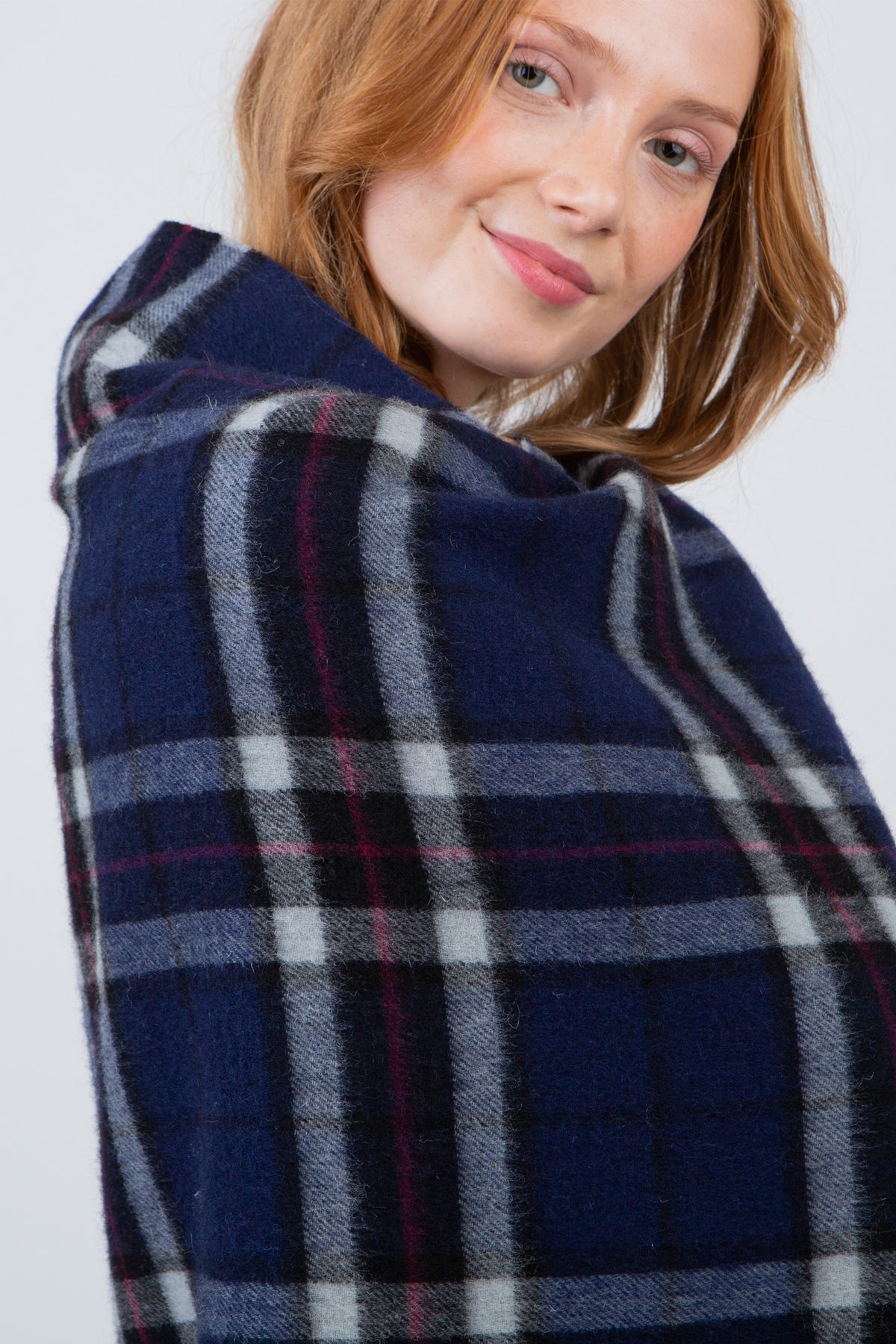 Model wrapped in Scotty Thompson Lambswool Stole in Navy, showing the soft plaid pattern with grey, white, and burgundy accents