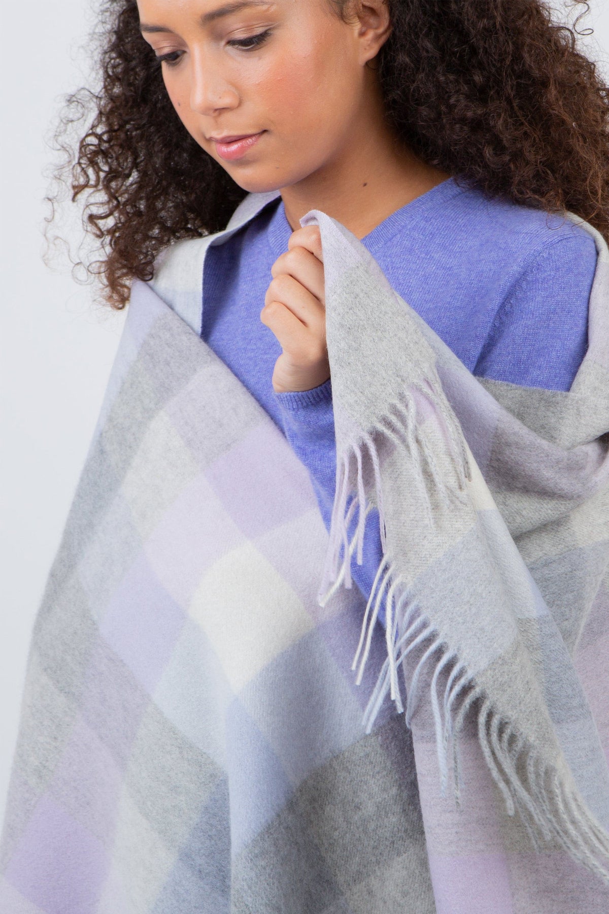 Model draping the 5 Square Check Lambswool Stole in Lilac, showing soft fringe detail and pastel check pattern up close