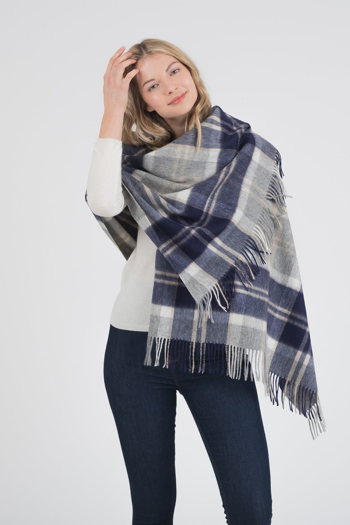 Heritage Tartan Lambswool Stole in Silver Bannockbane worn wrapped around shoulders, showing navy and grey plaid pattern with fringed edges