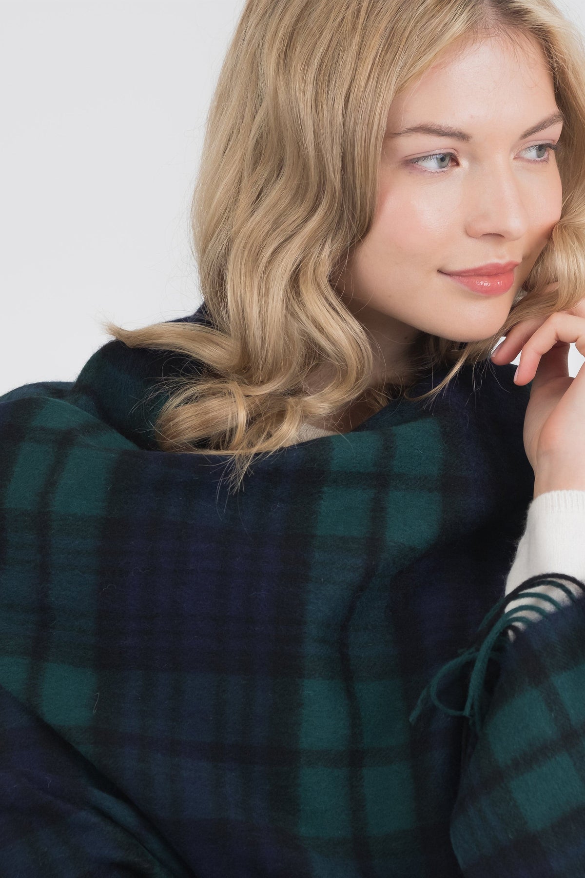 Heritage Tartan Lambswool Stole in Blackwatch draped over shoulders, showing the navy and green plaid pattern and fringed edge
