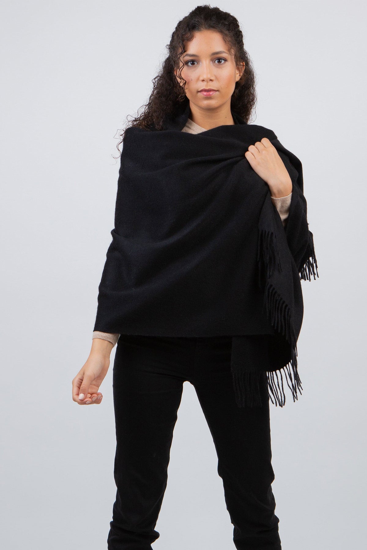 Model wearing Solid Lambswool Stole in Black draped over shoulders, showing soft texture and fringed edges