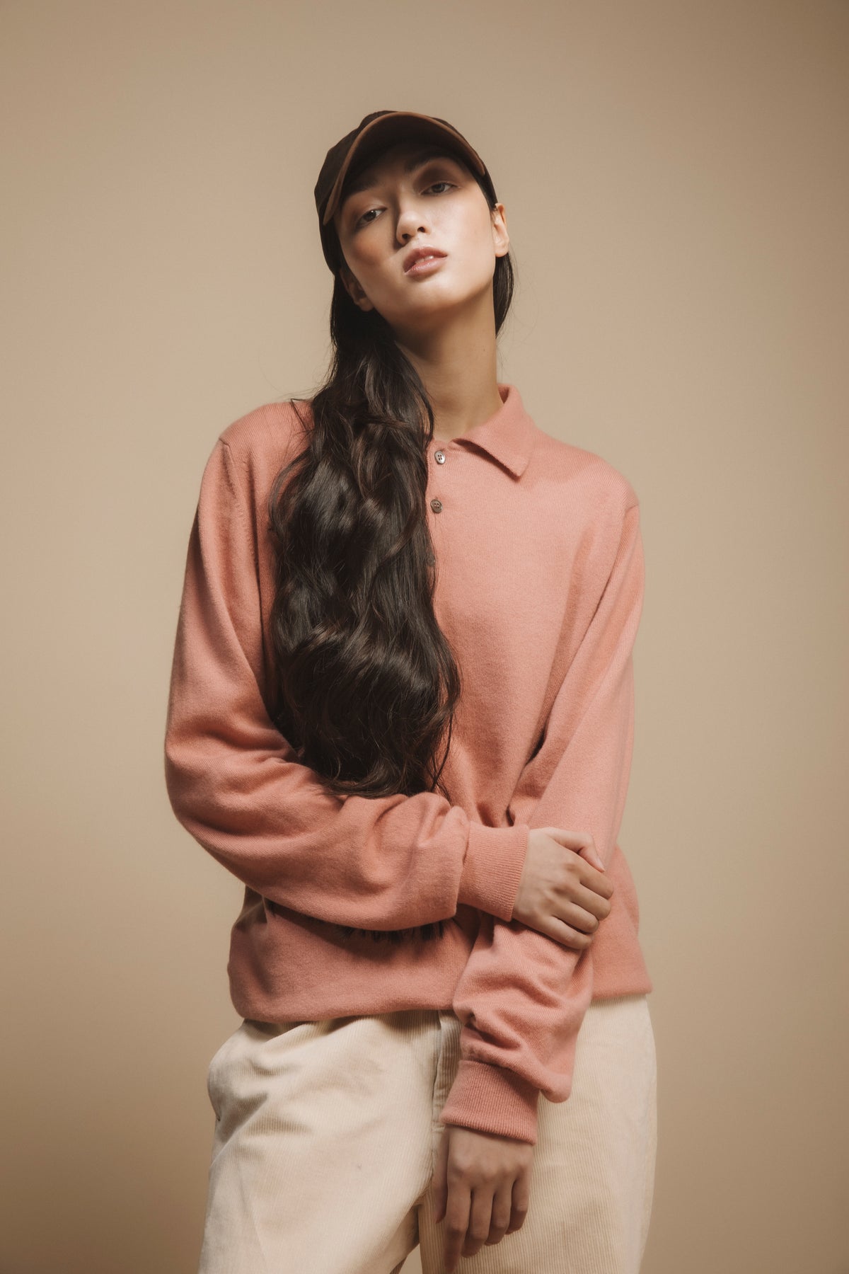Wax Baseball Cap in brown worn by model with long dark hair, styled with a dusty pink polo sweater