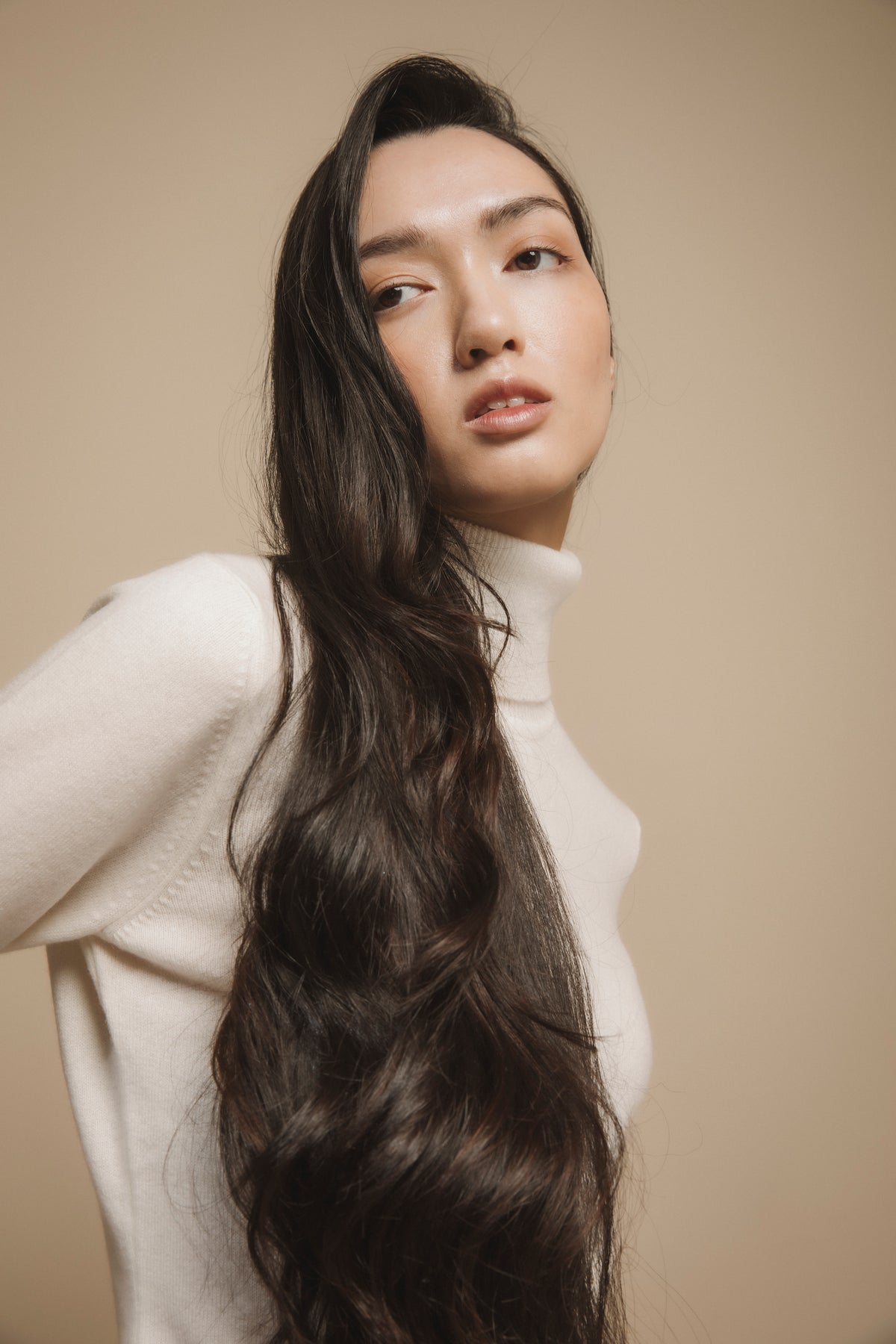 Women's Cashmere Polo Neck Jumper in Soft Cream styled on model, showing high neck detail and relaxed fit