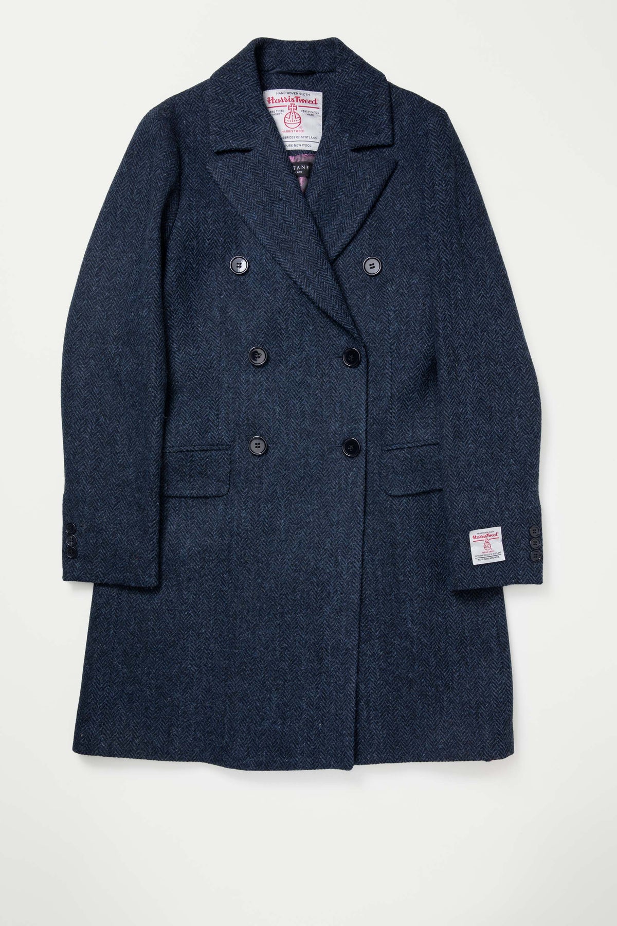Women's Harris Tweed Melody Coat in dark navy herringbone laid flat, showing double-breasted button front and flap pockets